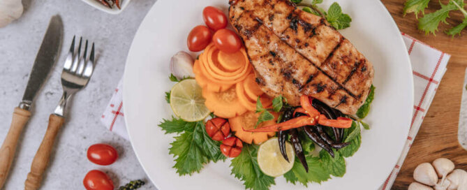 Foto com imagem de prato com peito de frango e salada